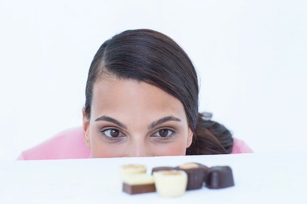 Pretty brunette peeking at chocolate