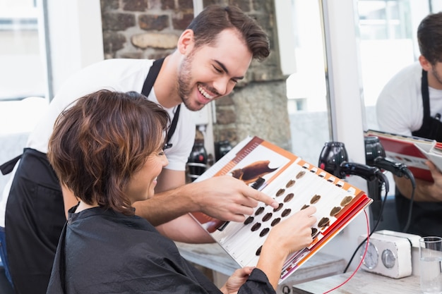 Pretty brunette picking out hair colour with stylist