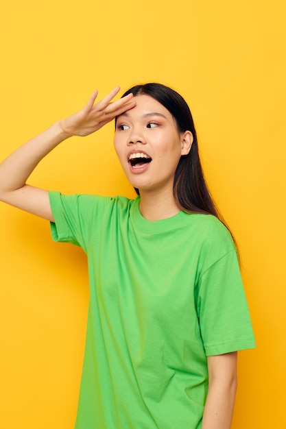 Pretty brunette posing in green tshirt emotions copyspace yellow background unaltered