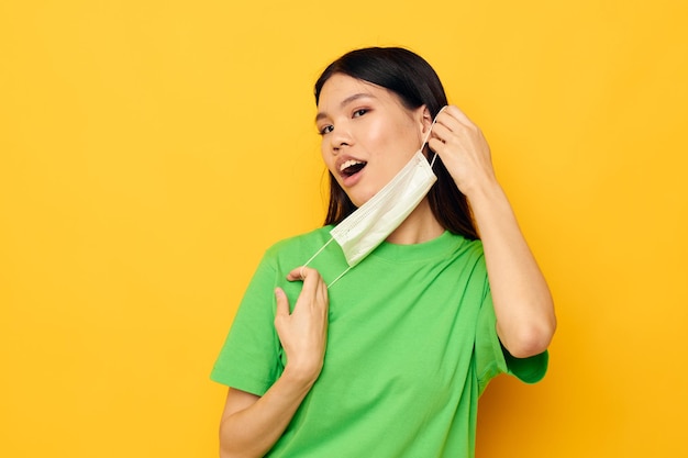 Pretty brunette posing wearing a medical mask safety fun isolated background unaltered