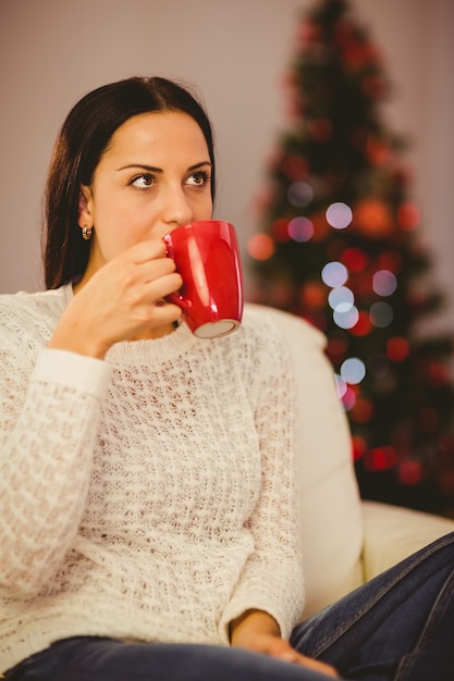 Abbastanza castana rilassandosi sul divano a natale