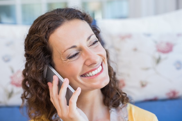 Pretty brunette sitting on the floor and speaking on the phone