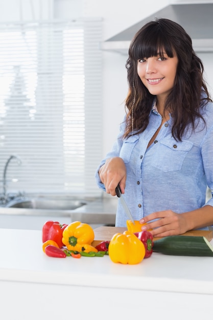 Pretty brunette slicing pepper