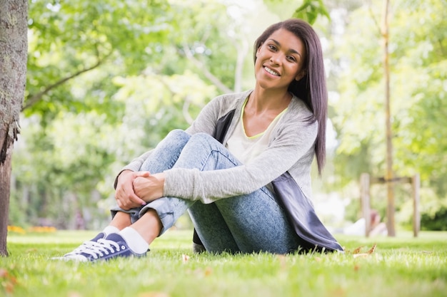 Pretty brunette smiling at camera in park