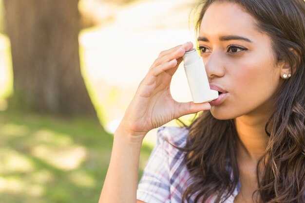 Pretty brunette using inhaler