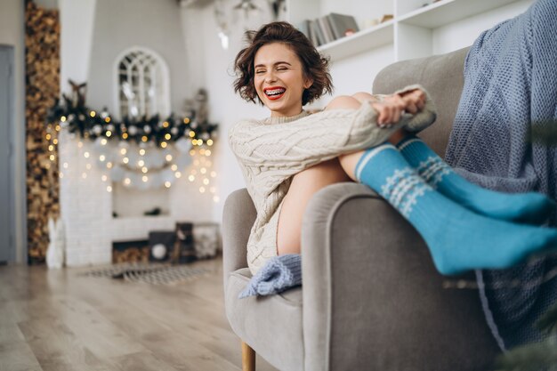 Pretty brunette in a warm sweater at home