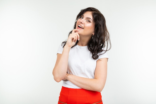 Pretty brunette in white t-shirt and red pants isolated on white background