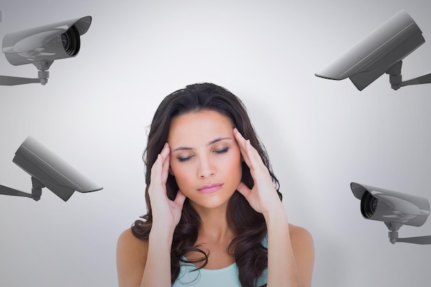 Pretty brunette with a headache against cctv camera