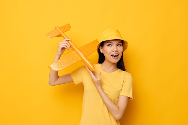 Pretty brunette with a yellow plane in his hands a toy isolated background unaltered