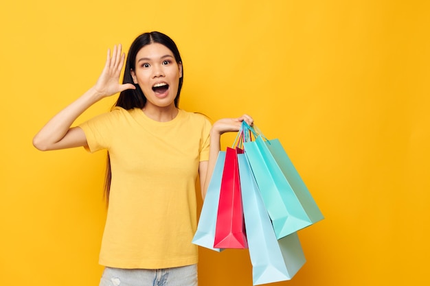 Pretty brunette woman with packages in hands shopping isolated background unaltered