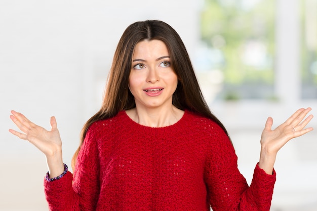 Pretty business woman holding her hands out saying that she does not know 