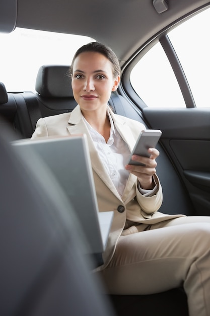 Photo pretty businesswoman working in the back seat