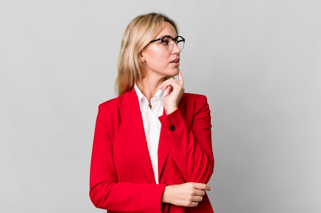 Pretty caucasian blonde businesswoman with red blazer