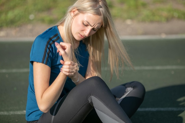 トレーニング後の手首に痛みを伴うかなり白人の女の子、スポーツの女性の健康に苦しんでいる