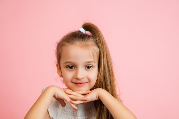 pretty caucasian girl portrait isolated on pink studio background with copyspace