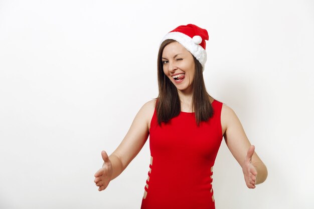 Pretty caucasian happy woman wearing red dress and Christmas hat holding copy space between palms for advertisement or text on white background. Santa girl isolated. New Year holiday 2018 concept.