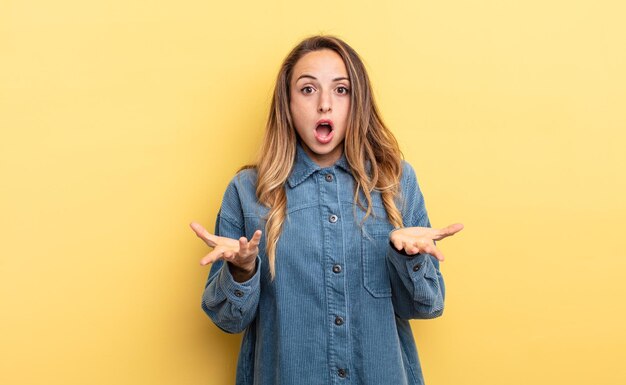 Pretty caucasian woman feeling extremely shocked and surprised, anxious and panicking, with a stressed and horrified look