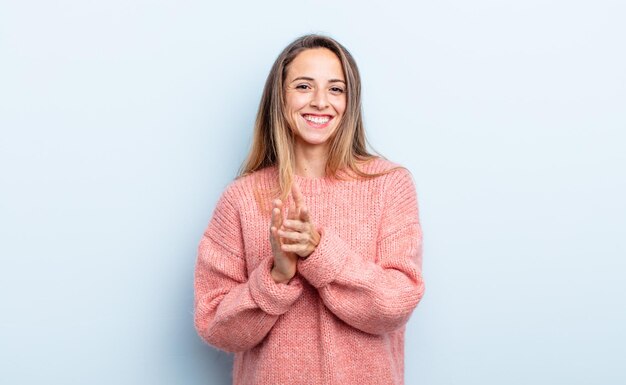 Pretty caucasian woman feeling happy and successful, smiling and clapping hands, saying congratulations with an applause