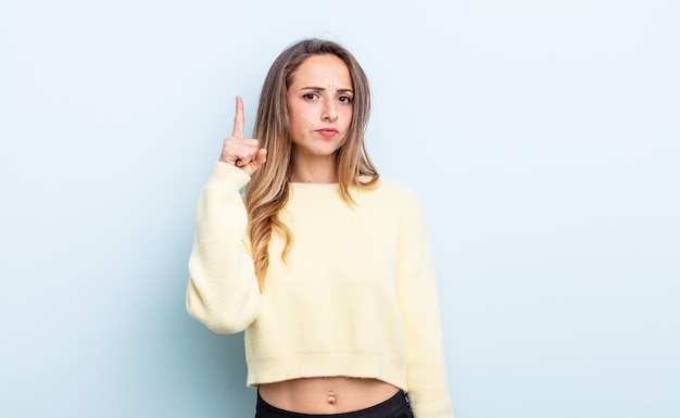 Pretty caucasian woman feeling like a genius holding finger proudly up in the air after realizing a great idea, saying eureka