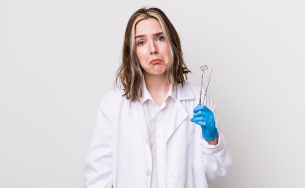 Pretty caucasian woman feeling sad and whiney with an unhappy look and crying dentist concept