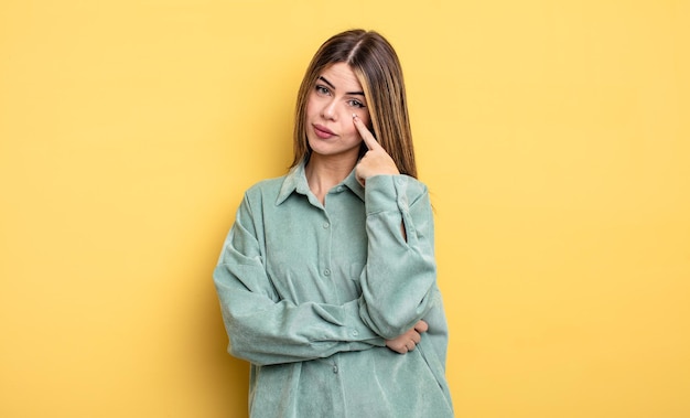 Pretty caucasian woman keeping an eye on you not trusting watching and staying alert and vigilant