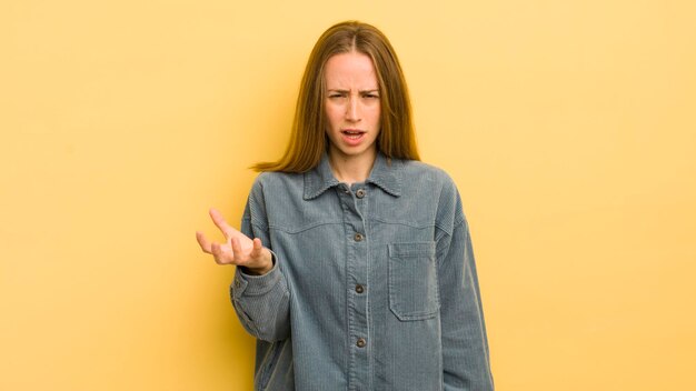 Pretty caucasian woman looking angry annoyed and frustrated screaming wtf or what's wrong with you