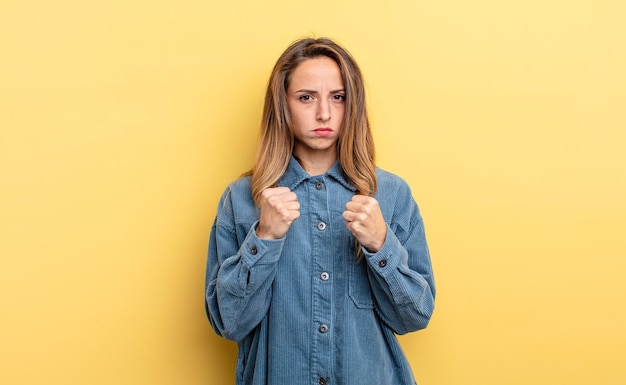 Pretty caucasian woman looking confident angry strong and aggressive with fists ready to fight in boxing position