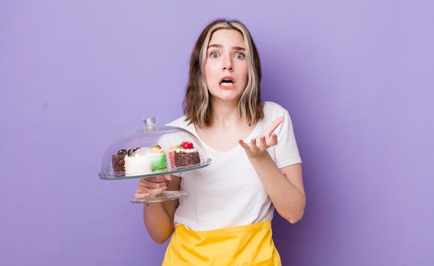 Pretty caucasian woman looking desperate frustrated and stressed home made cakes concept