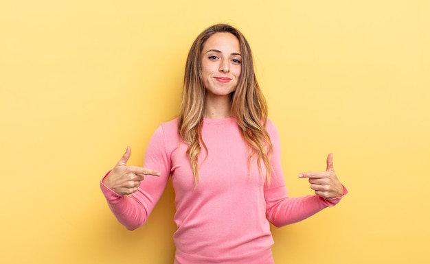 Photo pretty caucasian woman looking proud, arrogant, happy, surprised and satisfied, pointing to self, feeling like a winner