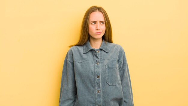 Pretty caucasian woman looking puzzled and confused wondering or trying to solve a problem or thinking