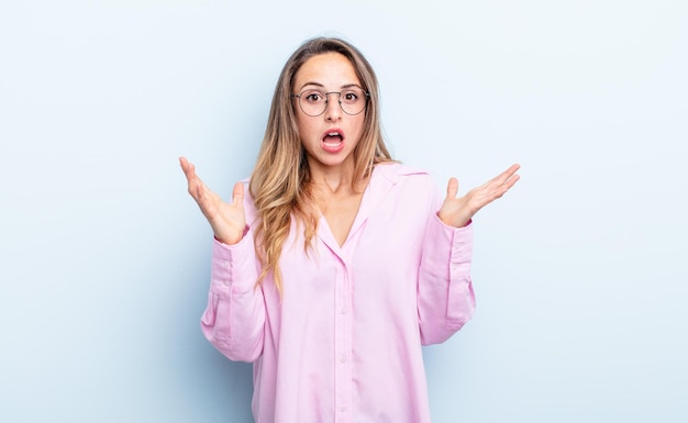 Pretty caucasian woman looking shocked and astonished, with jaw dropped in surprise when realizing something unbelievable