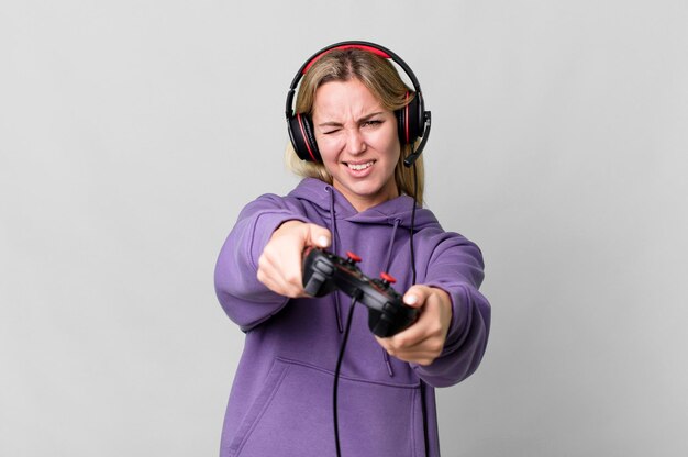 Photo pretty caucasian woman playing a computer game with headset and a controller