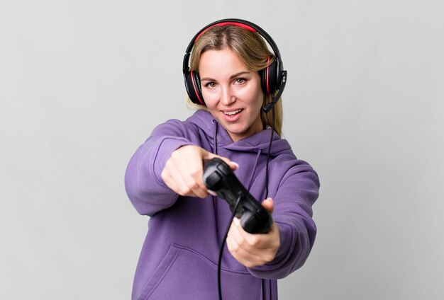 Pretty caucasian woman playing a computer game with headset and a controller