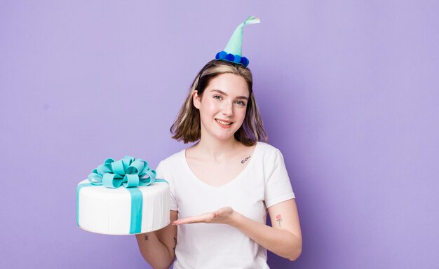 Donna abbastanza caucasica che sorride allegramente sentendosi felice e mostrando un concetto di compleanno