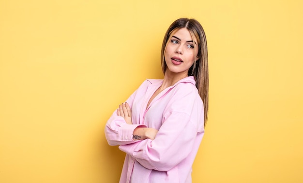 Pretty caucasian woman smiling gleefully feeling happy satisfied and relaxed with crossed arms and looking to the side