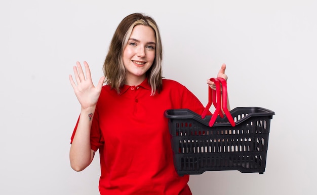 Pretty caucasian woman smiling and looking friendly showing number five empty shopping basket concept