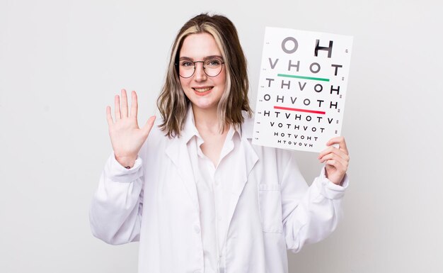 Pretty caucasian woman smiling and looking friendly showing number five optical concept