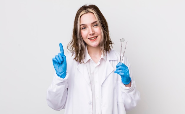 Pretty caucasian woman smiling and looking friendly showing number one dentist concept