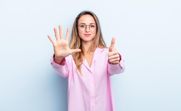 Pretty caucasian woman smiling and looking friendly, showing number six or sixth with hand forward, counting down