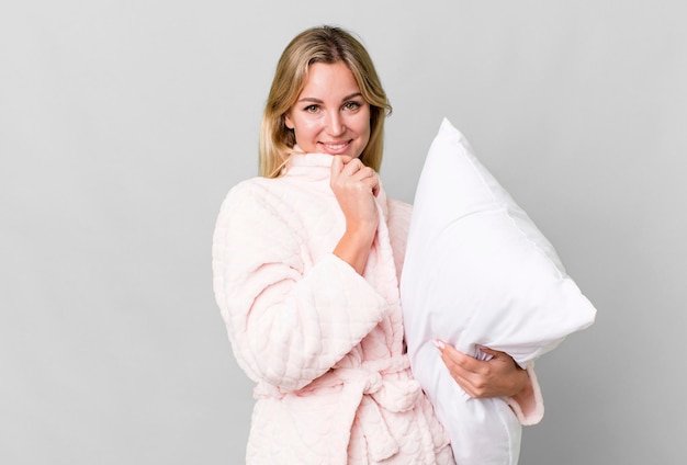 Pretty caucasian woman wearing night wear and a pillow