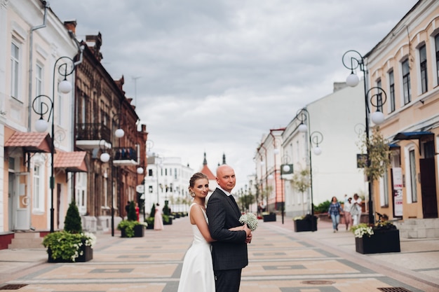 Pretty caucasian woman with fair hair loves her handsome strong husband without hair