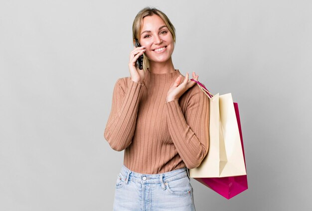 Pretty caucasian woman with shopping bags and a smartphone