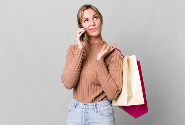 Pretty caucasian woman with shopping bags and a smartphone