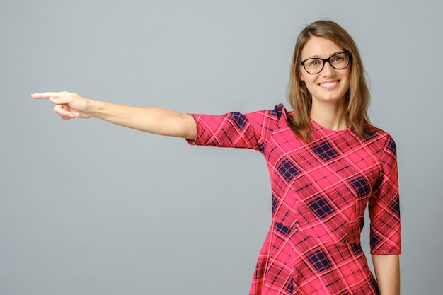 Pretty cheerful woman gesturing with fingers and hand and showing away