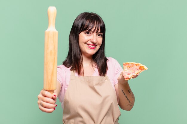 Довольно шеф-повар женщина счастливым выражением и держит пиццу