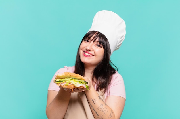 Pretty chef woman happy expression and holding a sandwich