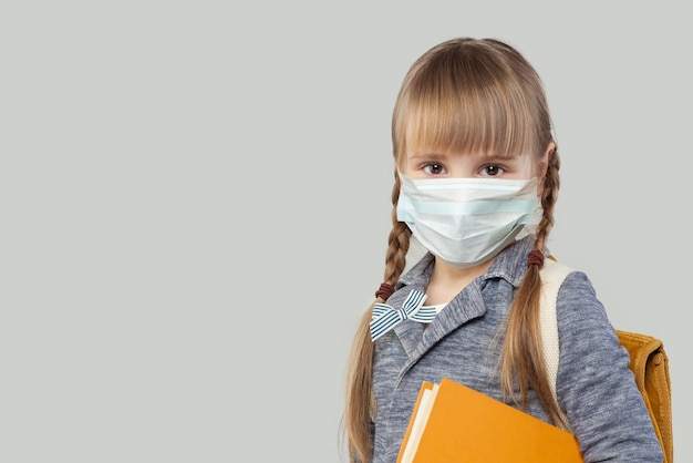 Pretty child girl in medical protective face mask on white background