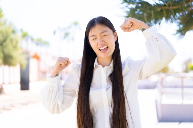 写真 勝利を祝って屋外でかなり中国の女性