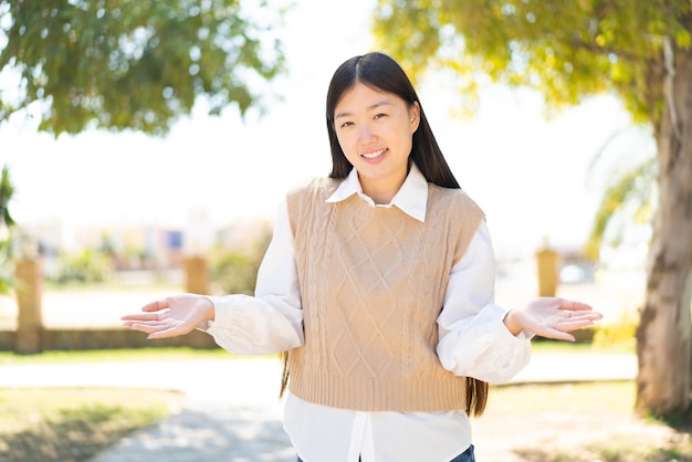 Donna abbastanza cinese a sorridere all'aperto