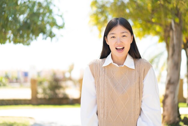 깜짝 표정으로 야외에서 예쁜 중국 여자